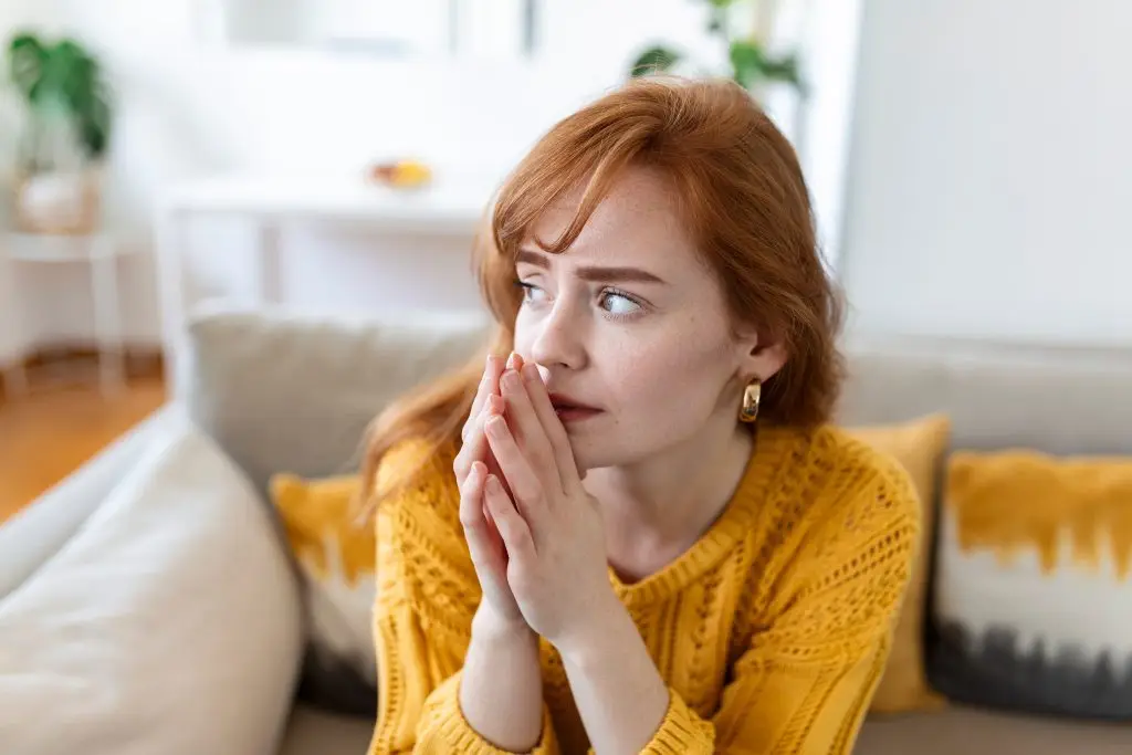 Woman sitting on a sofa experiencing symptoms of depression